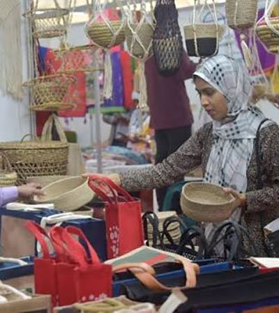 Bangladeshi woman entrepreneur serving customers at a small local business